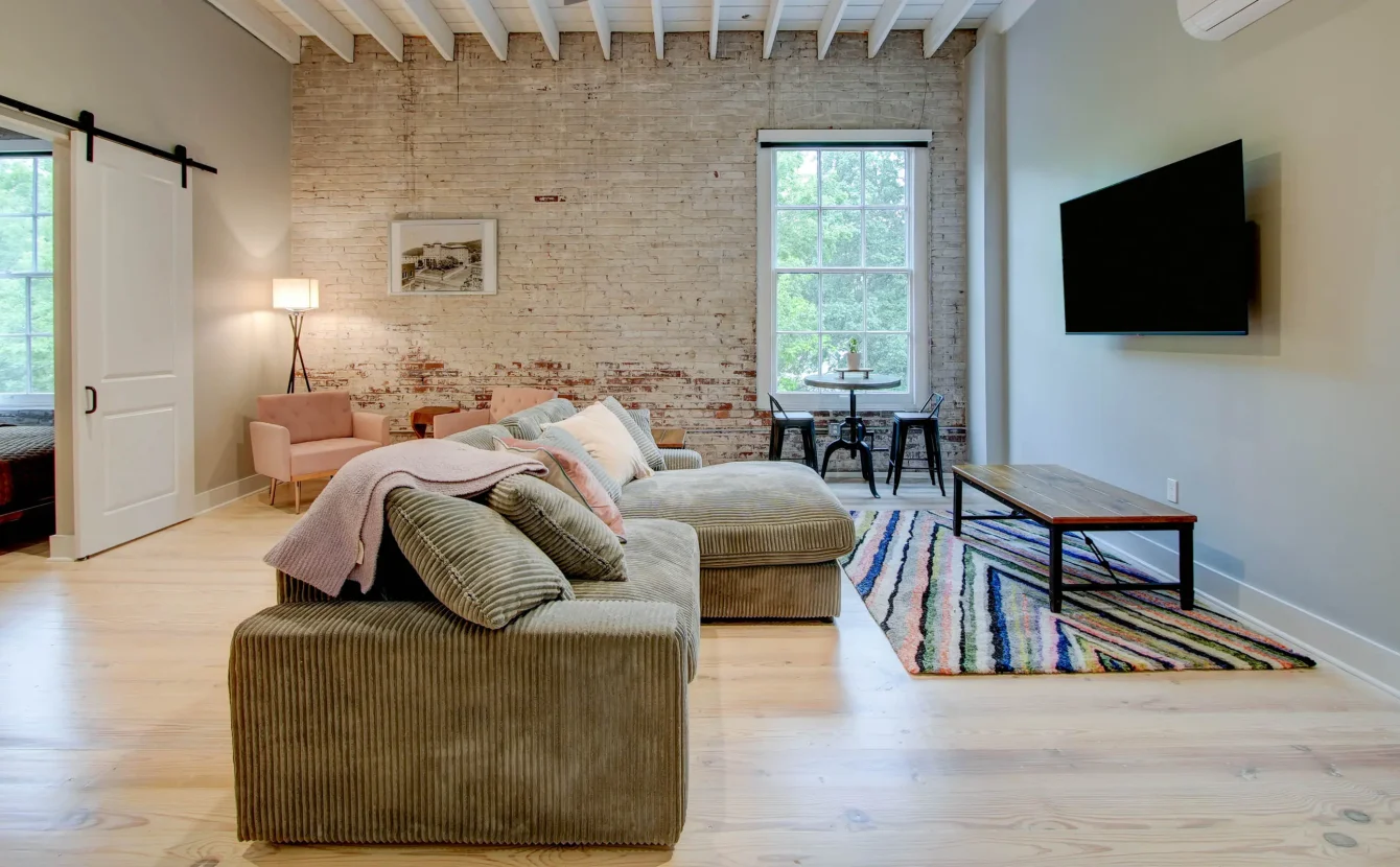 Living area with sectional sofa and dining nook in The Moody suite