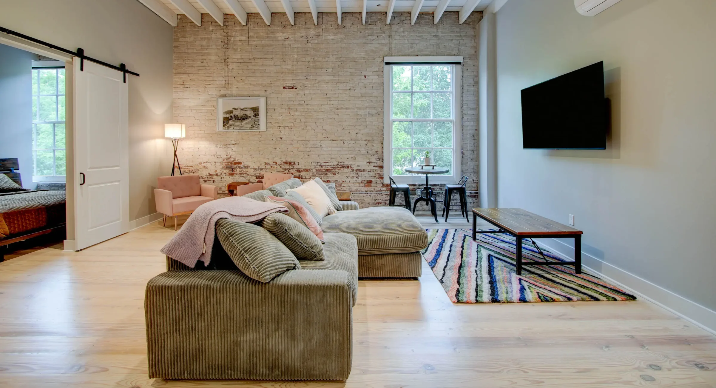 Living area with sectional sofa and dining nook in The Moody suite