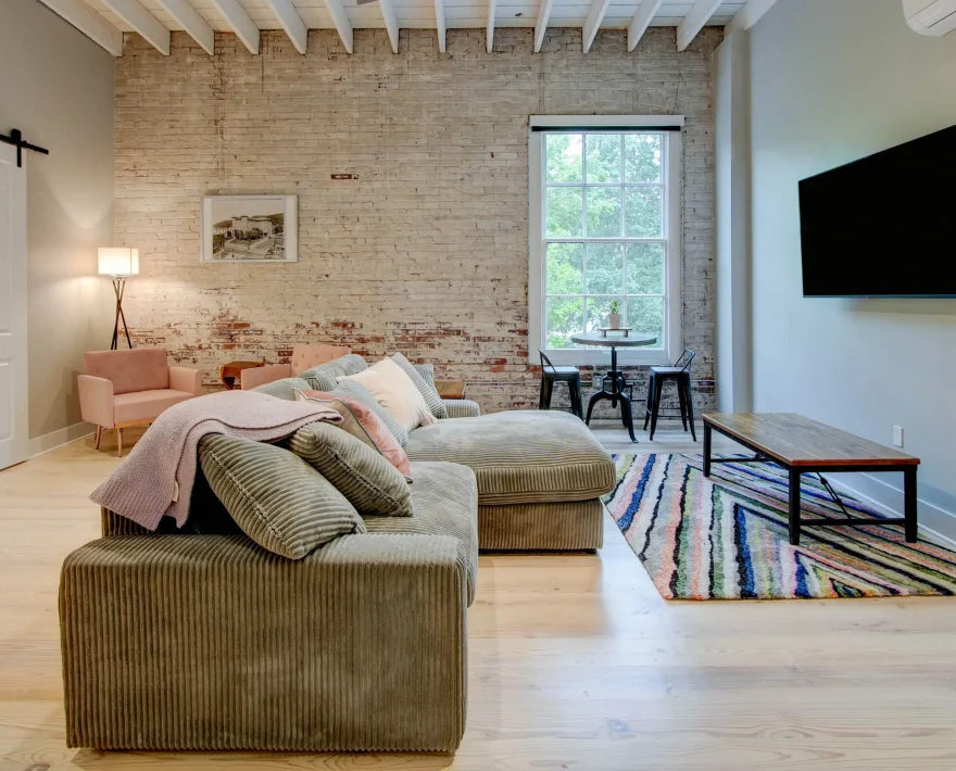 Living area with sectional sofa and dining nook in The Moody suite