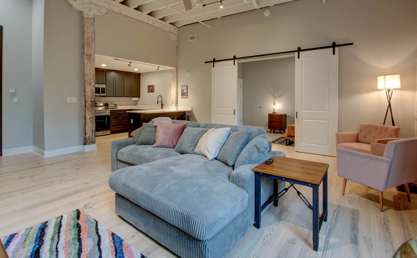 Spacious living room with brick wall and large window in The Moody suite