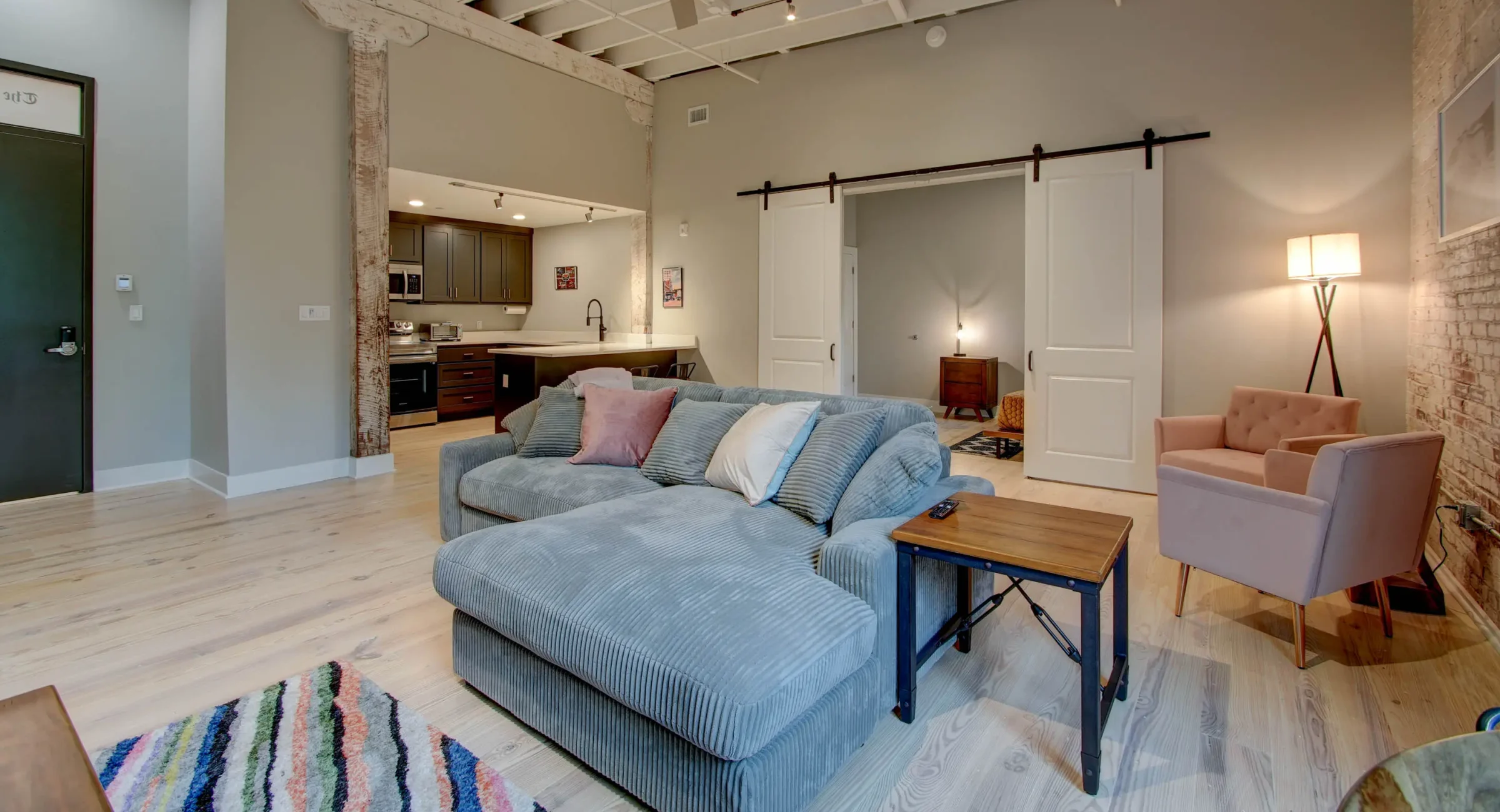 Spacious living room with brick wall and large window in The Moody suite