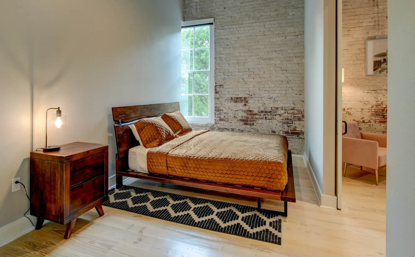 Bedroom with exposed brick wall in The Moody suite, downtown Hot Springs