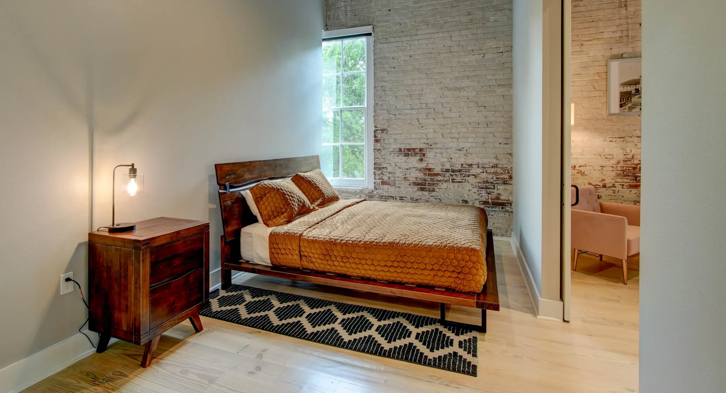 Bedroom with exposed brick wall in The Moody suite, downtown Hot Springs