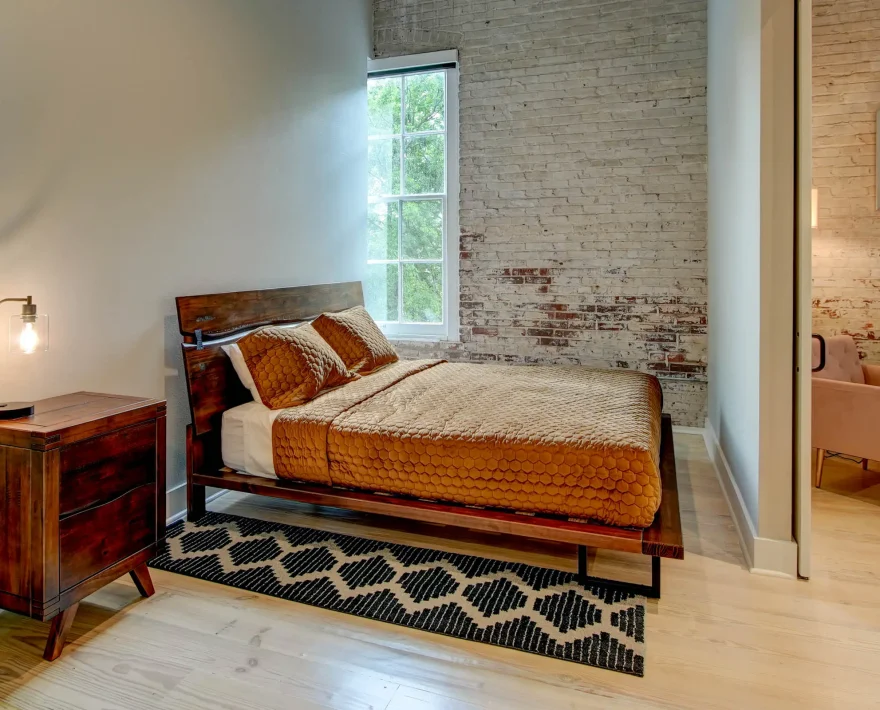 Bedroom with exposed brick wall in The Moody suite, downtown Hot Springs