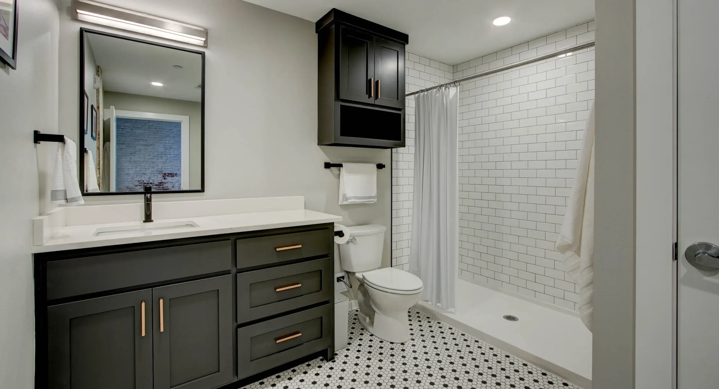 Bathroom with walk-in shower and subway tile in The Moody suite